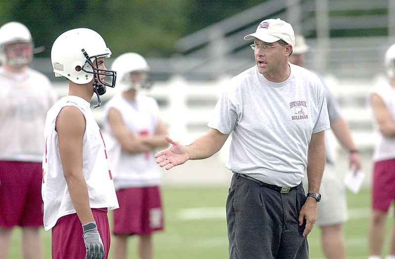 NWA Democrat-Gazette/ANDY SHUPE FILE PHOTO
Springdale coach Gus Malzahn, right, speaks with a player during practice Monday, Aug. 4, 2003 at Bulldog Stadium in Springdale.