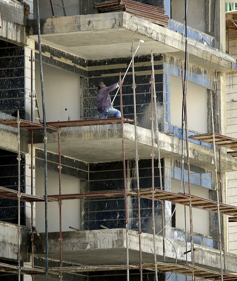 A Palestinian works on a building at the costal city of Ashkelon, Israel, Thursday, Nov. 20, 2014. Itamar Shimoni, Israeli mayor of the costal city of Ashkelon has suspended Israeli Arab laborers from work, renovating bomb shelters at local day-care centers. The move drew widespread criticism on Thursday, including from Netanyahu who said  "there is no place for discrimination against Israeli Arabs." (AP Photo/Tsafrir Abayov)