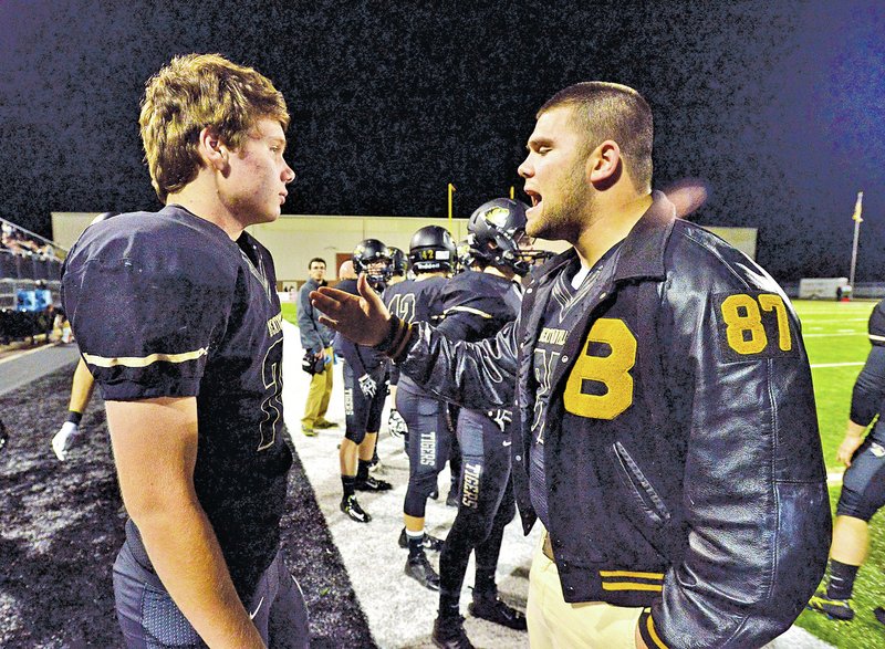  STAFF PHOTO BEN GOFF &#8226; @NWABenGoff Javier Carbonell, right, Bentonville senior defensive end, gives Noah Stubbs, junior defensive lineman, some pointers during the Nov. 7 game against Fayetteville in Bentonville&#8217;s Tiger Stadium.