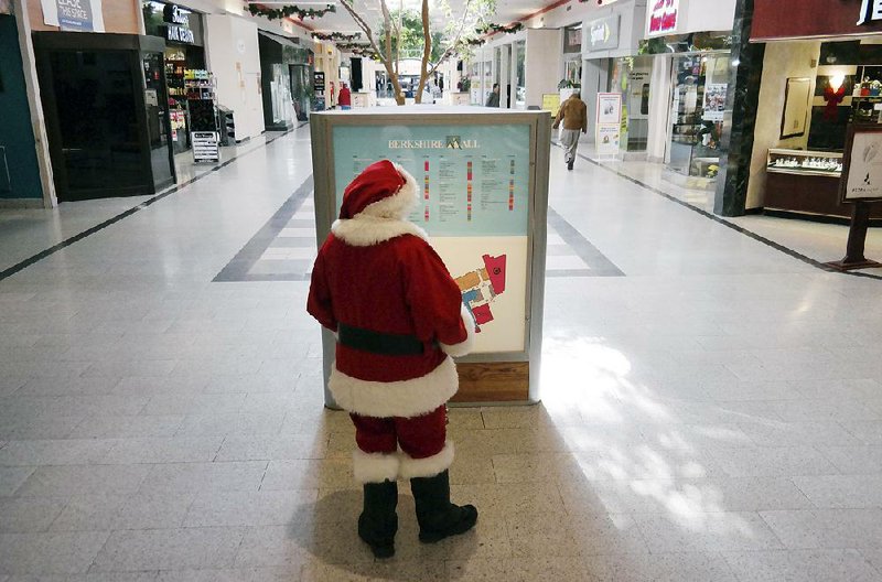 The Berkshire Mall Santa looks at the mall map kiosk to do some shopping of his own, Thursday Nov. 20, 2014, in  Lanesborough, Mass.  Retailers are preparing for black Friday and the kickoff of the holiday season. (AP Photo/The Berkshire Eagle, Ben Garver)
