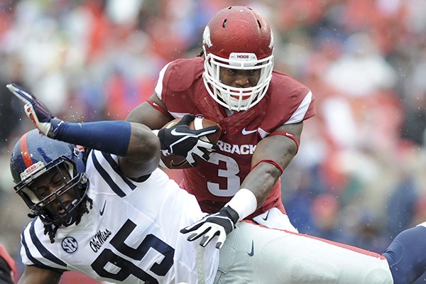 Arkansas running back Alex Collins (3) carries the ball over Mississippi defensive lineman Bryon Bennett (95) in the first quarter of an NCAA college football game Saturday, Nov. 22, 2014, in Fayetteville, Ark. (AP Photo/Sarah Bentham)