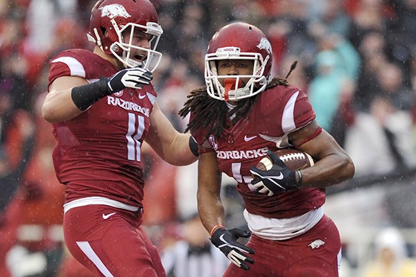 Arkansas tight end AJ Derby (11) celebrates with wide receiver Keon Hatcher (4) after Hatcher's first quarter touchdown in an NCAA college football game against Mississippi Saturday, Nov. 22, 2014, in Fayetteville, Ark. (AP Photo/Sarah Bentham)