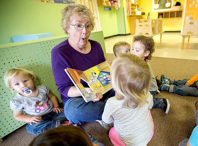 Mary Nolan reads to children Friday in the Siloam Springs Children’s Center. The Helen Walton Child Care Enrichment Center and the United Way of Northwest Arkansas are working with three child care centers in Northwest Arkansas on a study of barriers that the centers face in earning accreditation through the state’s voluntary Better Beginnings program.