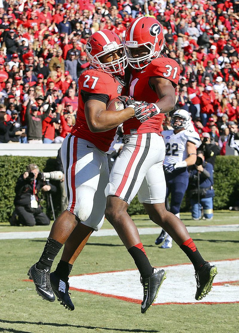 Georgia tailback Nick Chubb, left, celebrates his touchdown run with Chris Conley during the first quarter of an NCAA college football game against Charleston Southern, Saturday, Nov. 22, 2014, in Athens, Ga. (AP Photo/Atlanta Journal-Constitution, Curtis Compton)