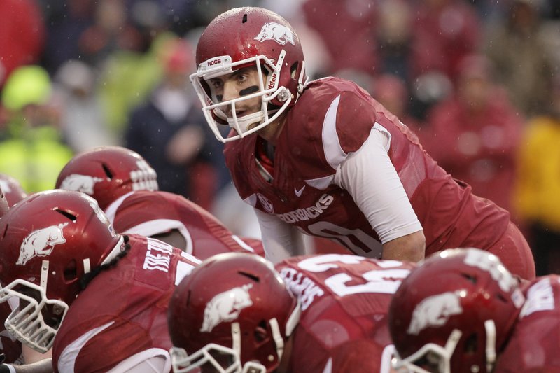 In this photo taken Nov. 22, 2014, in the first quarter of an NCAA college football game, Arkansas quarterback Brandon Allen, top, prepares for the snap against Mississippi. Arkansas gained bowl eligibility with its dominating win over Mississippi last week but the Razorbacks must get hobbled quarterback Allen healthy before Friday's game at Missouri. (AP Photo/Danny Johnston)