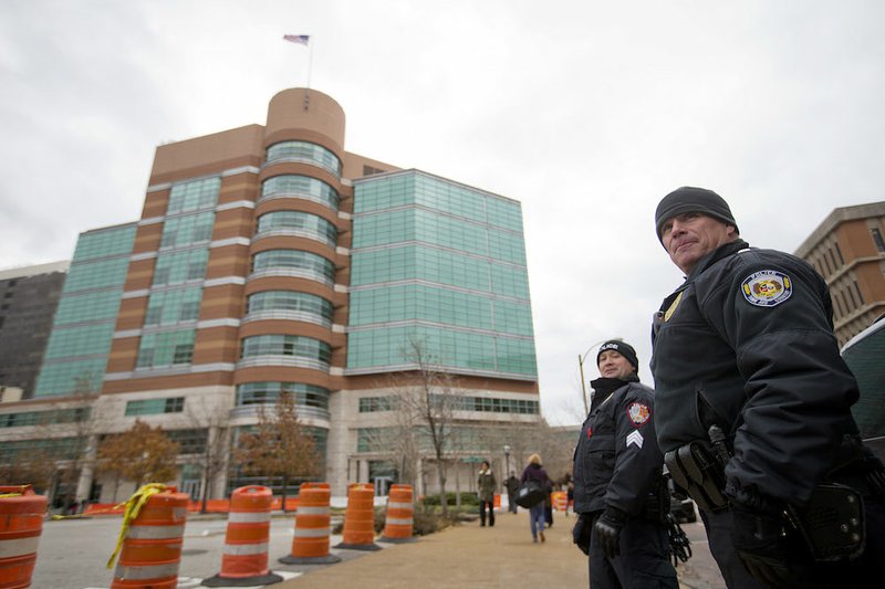 Police officers stand outside the Buzz Westfall Justice Center where a grand jury is convening to consider possible charges against the police officer who fatally shot Michael Brown in nearby Ferguson on Monday, Nov. 24, 2014, in Clayton, Mo. Ferguson and the St. Louis region are on edge in anticipation of the announcement by a grand jury whether to criminally charge Officer Darren Wilson in the killing of 18-year-old Michael Brown. 