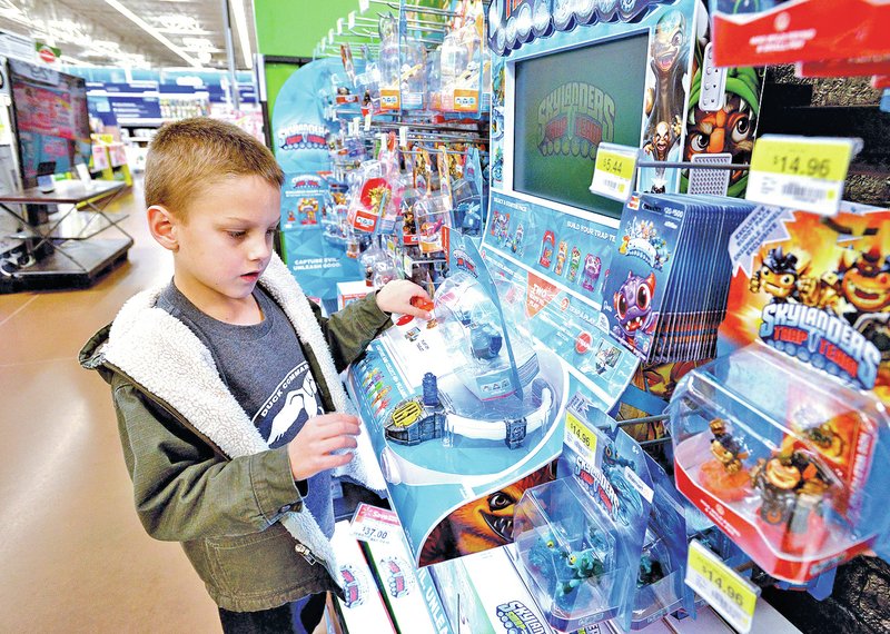  STAFF PHOTO BEN GOFF &#8226; @NWABenGoff Mason Gartrell, 6, of Rogers looks at Skylanders Trap Team toys Monday while making a Christmas wish list with his mother at the Walmart Supercenter on Pleasant Crossing Boulevard in Rogers.