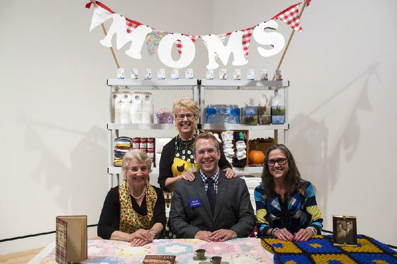 Andy DuCett and his mother, Marilyn DuCett (standing behind him), pose with volunteers staffing his art installation Mom Booth at Crystal Bridges Museum of American Art. The “moms” are Mary Kay Franklin of Bentonville (far left) and Deborah Tedford of Siloam Springs (far right).