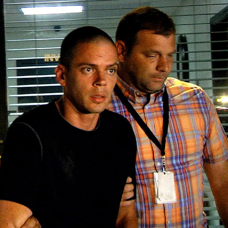 Suspect Arron Lewis (left) is escorted from the Pulaski County Sheriff's department by investigators after being interrogated, September 30, 2014 in this file photo.