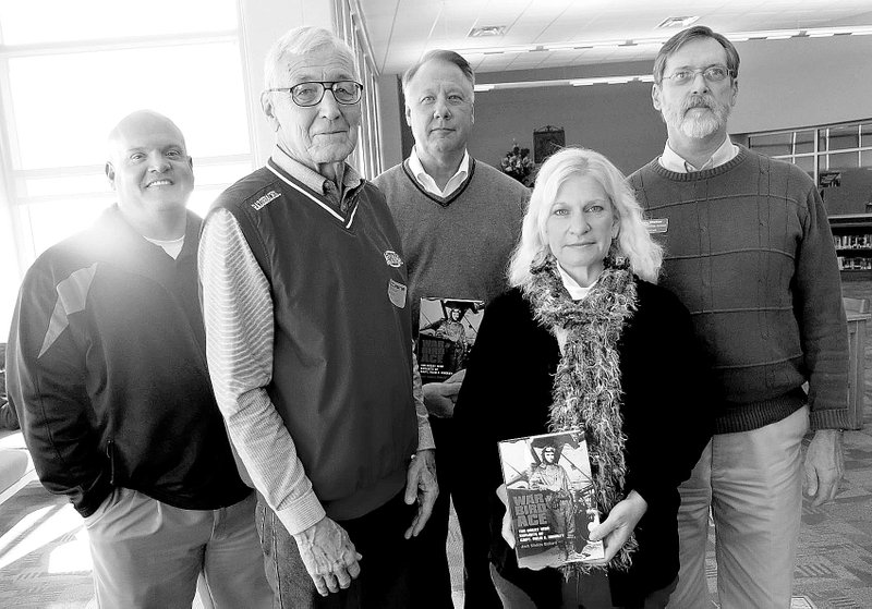 Photo by Susan Holland Museum commission chairman John Mitchael, second from left, donated copies of &#8220;War Bird Ace,&#8221; Jack Ballard&#8217;s biography of World War I ace Field Kindley, to the high school library and the middle school library on Nov. 6. On hand for the presentation in the high school library were Jay Chalk, high school principal; Richard Page, superintendent of Gravette schools; Janna Sharp, high school librarian; and Mike Walker, middle school librarian.