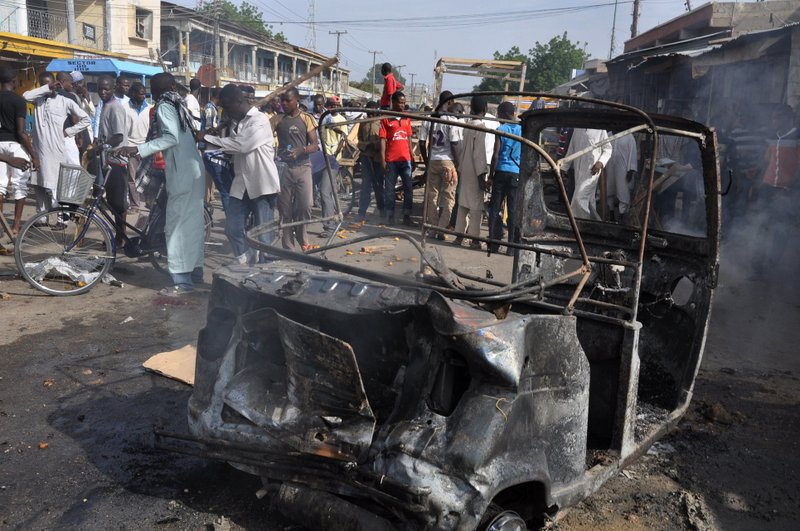 In this Tuesday, July, 2014 file photo, People gather at the scene of a car bomb explosion, at the central market, in Maiduguri, Nigeria. Today, Tuesday, Nov. 25, 2014, two female suicide bombers blew themselves up in a crowded market in Nigerias northeastern city of Maiduguri, killing at least 30 people, according to witnesses and a security official. The two teenage girls dressed in full hijabs entered the busy market and detonated their explosives, said Abba Aji Kalli, the Borno state coordinator of the Civilian Joint Task Force.