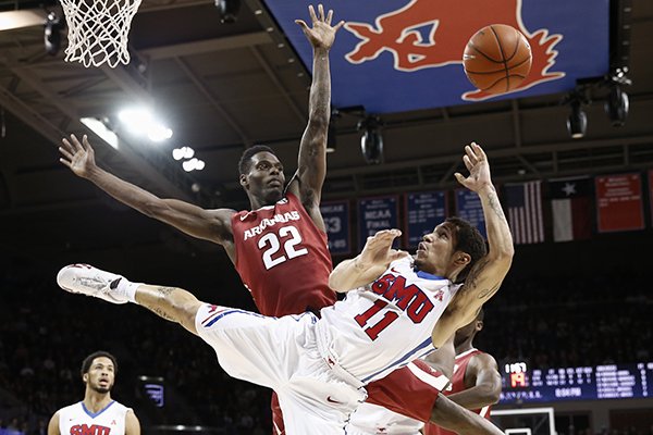 Southern Methodist Mustangs guard Nic Moore (11) falls as he shoots the ball over Arkansas Razorbacks forward Jacorey Williams (22) during the second half of an NCAA basketball game, Tuesday, Nov. 25, 2014, in Dallas. Arkansas won 78-72. (AP Photo/Jim Cowsert)