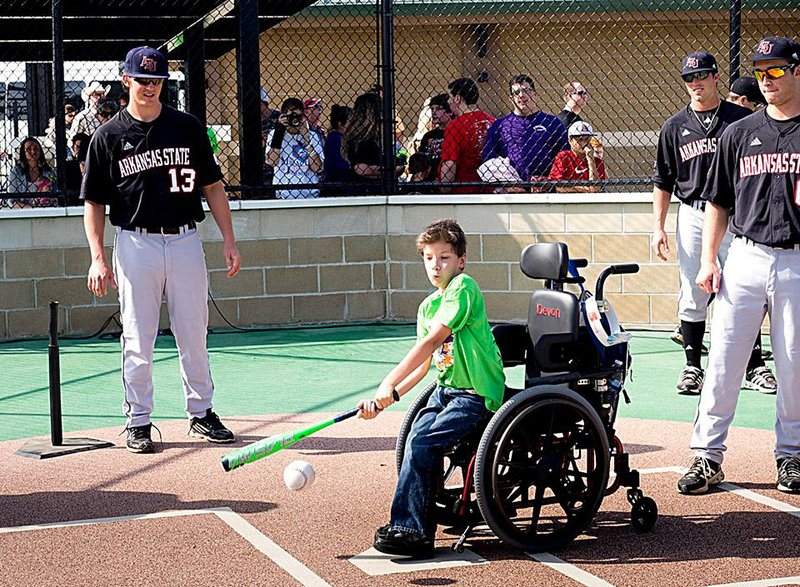 Devon Robinson swings at a pitch during the October opening of the Miracle League of Jonesboro’s baseball field and playground.