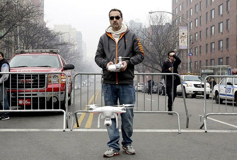 In this photo from March, a man launches a private drone to fly over the scene of an apartment building explosion in the East Harlem section of New York. The Federal Aviation Administration is trying to impose order on the fast-growing use of the unmanned aircraft.