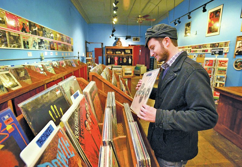STAFF PHOTO BEN GOFF &#8226; @NWABenGoff Kegan Johnson of Fayetteville thumbs through vinyl records Tuesday at Block St. Records in downtown Fayetteville. The new business, which opened Monday, buys, sells and trades in vinyl, turntables an other vintage music.