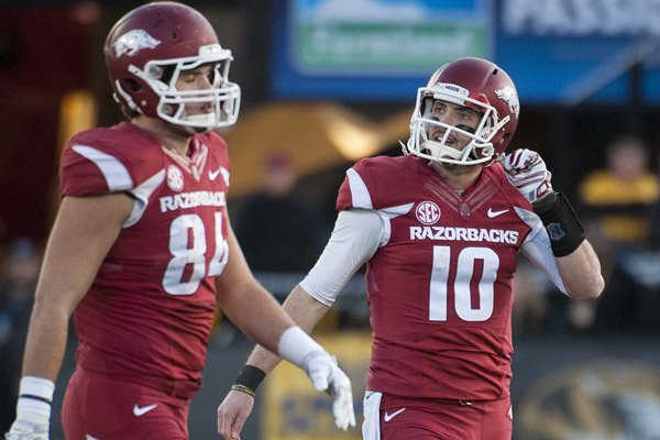 Arkansas quarterback Brandon Allen takes his helmet off as he walks to the sideline with teammate Hunter Henry after Allen was sacked during the third quarter of an NCAA college football game against Missouri Friday, Nov. 28, 2014, in Columbia, Mo. Missouri won 21-14. (AP Photo/L.G. Patterson)