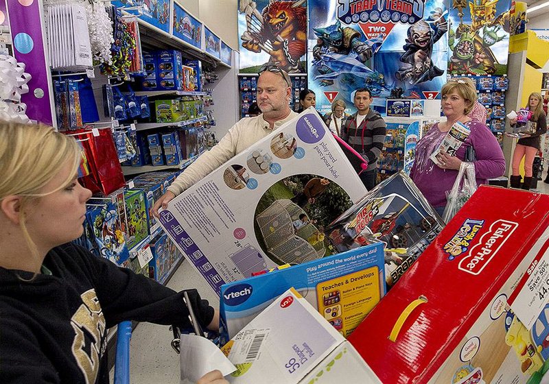 Summer Hogan (left) of Carlisle and James Clayton of Batesville shop for Black Friday deals late Thursday at Toys R Us in North Little Rock. Thanksgiving Day deals tempt, but some who were out had mixed feelings about shopping on the holiday. 