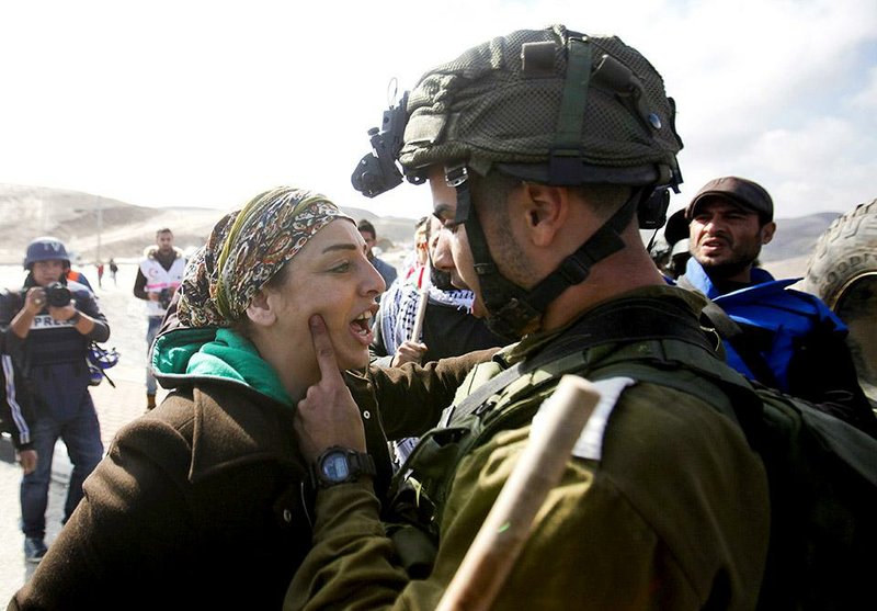 An Israeli soldier argues with a Palestinian protester Friday as protesters try to block a highway between Jerusalem and the Dead Sea near the West Bank town of Jericho. Meanwhile, French lawmakers were debating a nonbinding motion to recognize a Palestinian state.