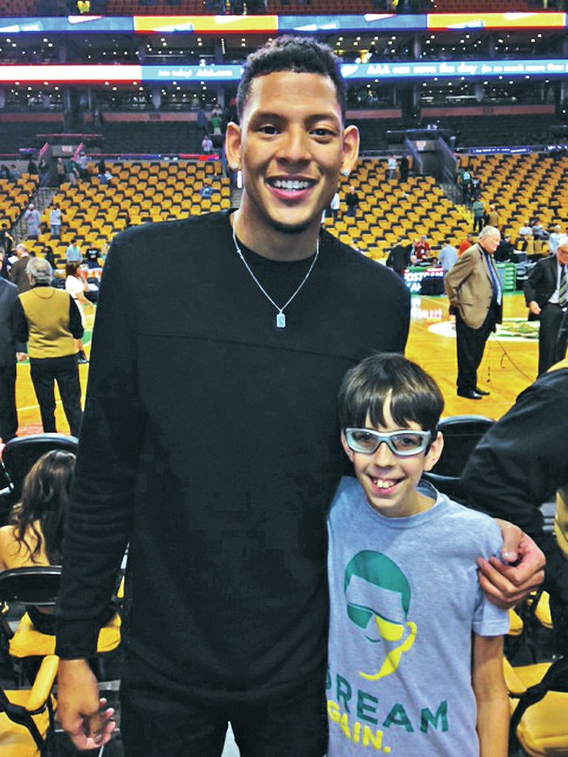 SUBMITTED PHOTO Isaiah Austin, left, and Aaron Childress, are pictured together Oct. 29 at TD Garden in Boston. Austin, a 7-foot-1 former All-conference basketball player at Baylor University, was diagnosed with Marfan&#8217;s syndrome just days before entering the NBA Draft in June. Childress, a Springdale Monitor Elementary fifth-grader, was diagnosed Sept. 15 with Marfan&#8217;s and was forced to give up his favorite sport of basketball. Both Austin and Childress have now switched to coaching the sport.