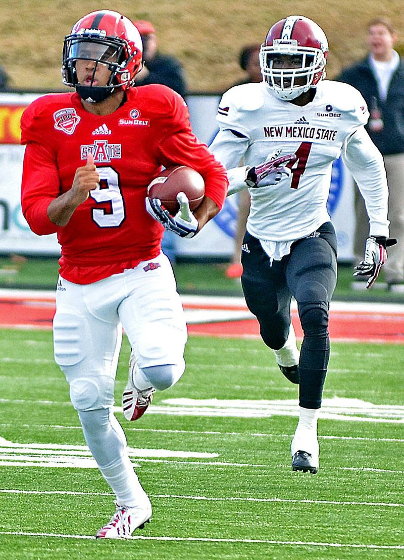 Arkansas State quarterback Fredi Knighten (9), racing past New Mexico State’s Winston Rose, accounted for four touchdowns in the Red Wolves’ 68-35 victory.
