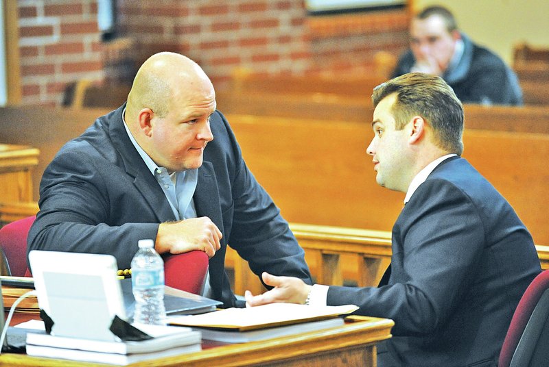 STAFF PHOTO ANDY SHUPE Josh Melton of Fayetteville, left, speaks Monday with his attorney, Drew Ledbetter, during the first day of Melton&#8217;s trial at the Washington County Courthouse in Fayetteville.