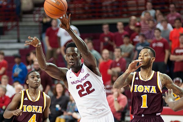 Arkansas' Jacorey Williams (22) passes the ball next to Iona's Schadrac Casimir (4) and Isaiah Williams (1) in the first half of an NCAA college basketball game in Fayetteville, Ark., Sunday, Nov. 30, 2014. (AP Photo/Sarah Bentham)