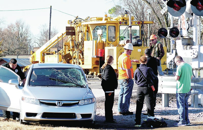 Photo by Randy Moll Police and representatives from the Kansas City Southern Railroad investigate a crash which occurred about 10 a.m. Nov. 24 at the Main Street crossing of the KCS line in Gentry. No one was seriously injured in the crash between the heavily damaged Honda automobile in the foreground and the railway maintenance equipment in the background.