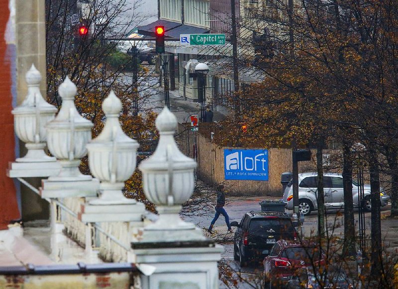 A woman crosses Main Street at Capitol Avenue on Wednesday near a construction project in downtown Little Rock. Downtown property owners spoke Wednesday against a proposed downtown design district that would run from Markham Street to Interstate 630 and from Center Street to Cumberland Street.