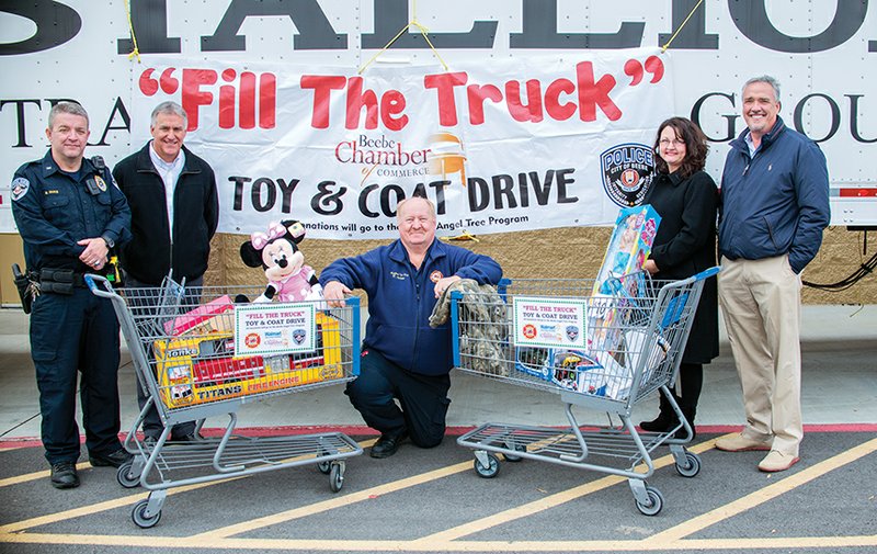 From left, Brian Duke; Tim Hammack; Rick Jackson; Kristen Boswell, executive director of the Beebe Chamber of Commerce; and Butch Rice, president and CEO of Stallion Transportation, participate in the Fill the Truck Toy and Coat Drive at the Walmart Supercenter in Beebe.