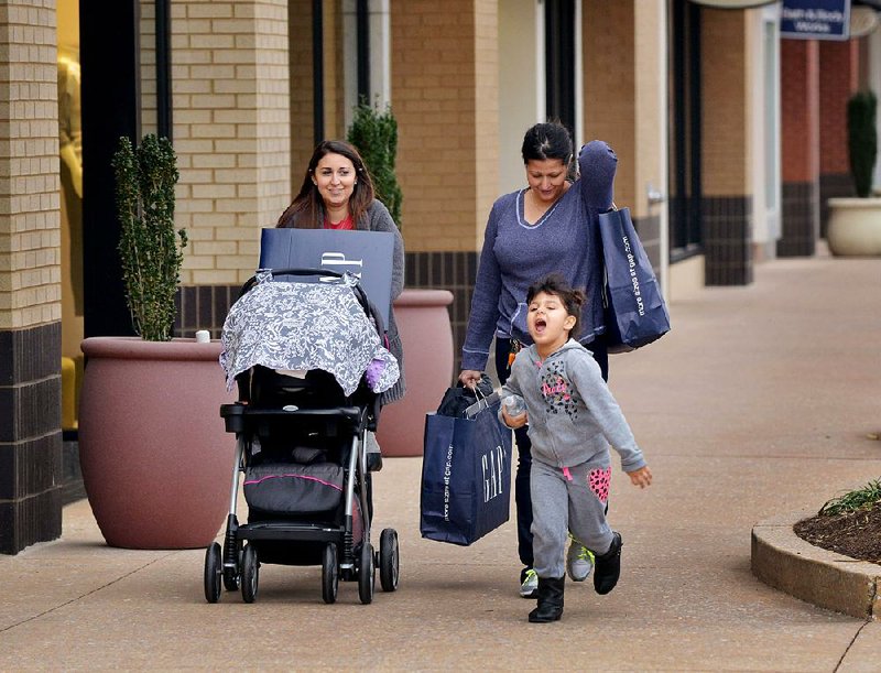 STAFF PHOTO BEN GOFF  @NWABenGoff -- 12/03/14 Brittany Harper, from left, pushes her infant daughter Scarlett Harper while shopping with her mother Stella Peterson and sister Mattea Peterson, 4, at Pinnacle Hills Promenade in Rogers on Wednesday Dec. 3, 2014. 