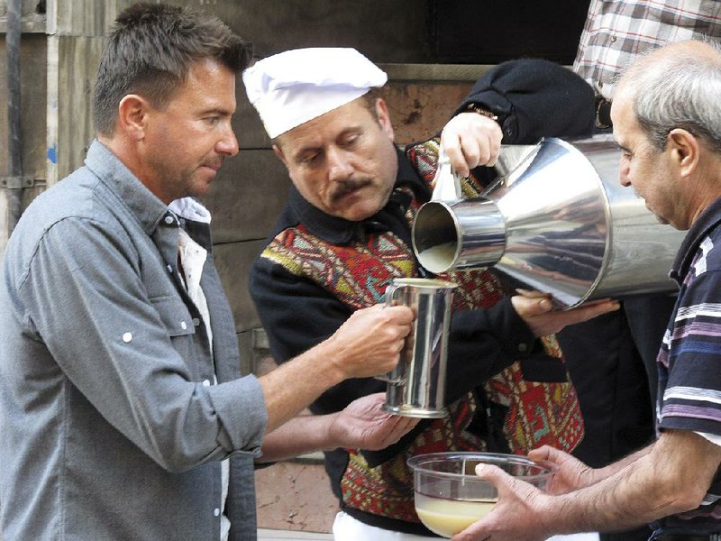 In this April 19, 2014 photo released by the Travel Channel, Jack Maxwell, left, helps deliver the popular fermented beverage boza in Istanbul, Turkey. Maxwell, of Boston, will host "Booze Traveler," where he explores places, customs and cultures behind drinks around the globe. The program debuts Sunday, Nov. 24 on the Travel Channel. (AP Photo/Travel Channel)