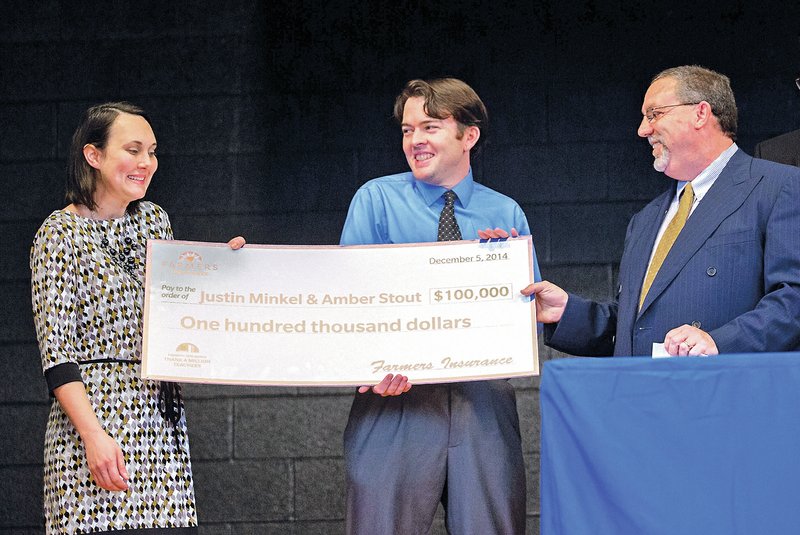 STAFF PHOTO JASON IVESTER Teachers Amber Stout, from left, and Justin Minkel are presented a check Friday from Greg Collier with Farmers Insurance, for $100,000from the Thank a Million Teachers/Dream Big Challenge at Jones Elementary School in Springdale. The grant will be used to buy 25,000 books for 1,000 students in three Springdale elementary schools.