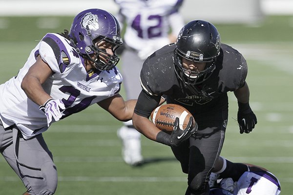 Bentonville High School running back Dylan Smith, right, carries past Fayetteville High School defensive end Damani Carter, left, in the first half of the Arkansas Class 7A high school championship football game in Little Rock, Ark., Saturday, Dec. 6, 2014. (AP Photo/Danny Johnston)
