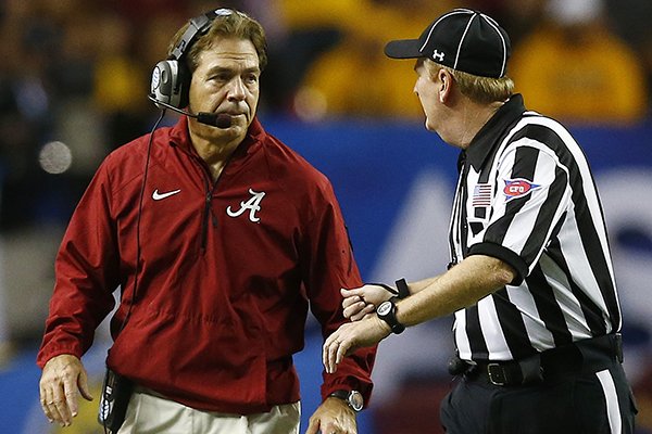 Alabama head coach Nick Saban speaks with an official after Alabama quarterback Blake Sims was hit late by Missouri defensive lineman Shane Ray during the first half of the Southeastern Conference championship NCAA college football game, Saturday, Dec. 6, 2014, in Atlanta. (AP Photo/John Bazemore)