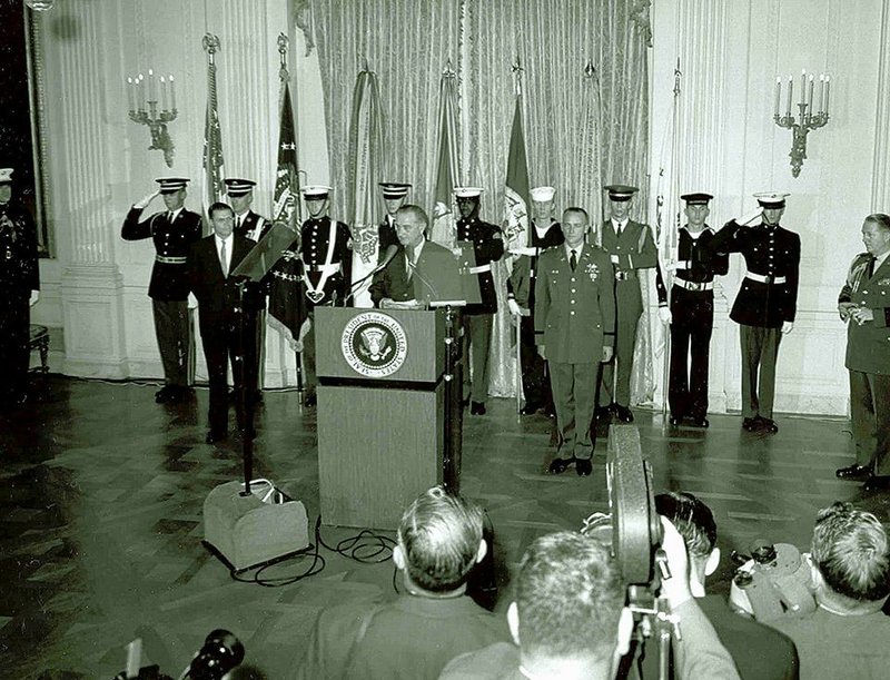 Capt. Roger Donolon, standing at attention at right, waits to receive his Medal of Honor from President Lyndon B. Johnson at the White House on Dec. 5, 1964. Donlon, a native of Saugerties, N.Y., now living in Leavenworth, Kan., was the first person to receive the Medal of Honor in the Vietnam War. Illustrates VIETNAM-MEDAL (category a), by Michael E. Ruane (c) 2014, The Washington Post. Moved Thursday, Dec. 4, 2014. (MUST CREDIT: U.S. Army)