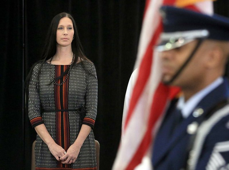 Arkansas Democrat-Gazette/RICK MCFARLAND  --12/06/14--  Suzanne Wassom stands as the Colors are presented during a ceremony to honor her late husband MSgt. Dan Wassom, Jr., a C-130 evaluator loadmaster with the Arkansas Air National Guard at the Little Rock Air Force Base in Jacksonville Saturday. Wassom died while shielding his daughter when an EF-4 tornado hit Vilonia last April.  A street on base will be dedicated and renamed MSgt. Dan Wassom Road.