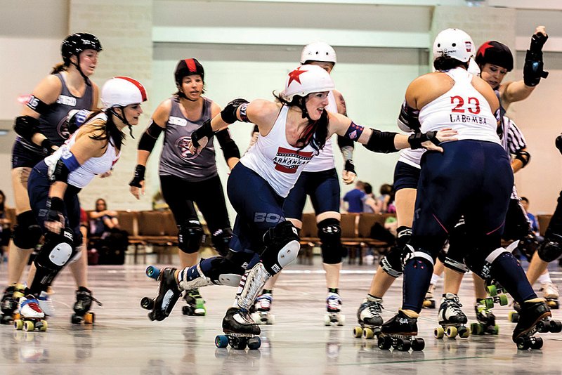 As Arkansas makes quick work of Alabama in the fi rst State Wars Roller Derby tournament, jammer
JoAnn Sarquist, aka JoAnn of Arc, takes advantage of blocking by Cortney “LaBomba” Reyes
(right). At left is pivot Emma “The Denialator” Bridwell. Arkansas won 327-41.