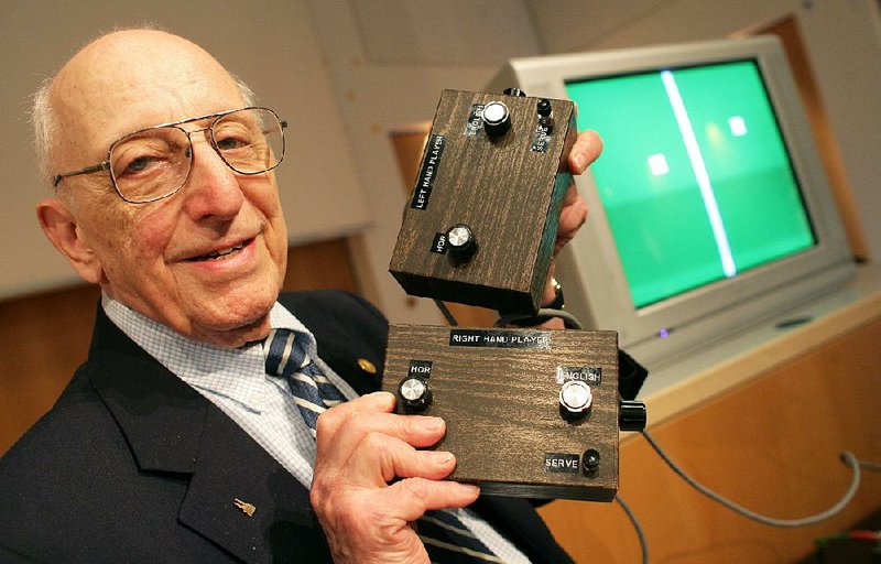 FILE - In this July 2009 file picture , German-American game developer Ralph Baer shows the prototype of the first games console, invented by him during a press conference  at the Games Convention Online in Leipzig, Germany.  The video game pioneer who created both the precursor to "Pong" and the electronic memory game "Simon" has died. Ralph Baer also was leader of the team that developed the Magnavox Odyssey, the first home video game console. Baer,  who was born in Germany and escaped the Holocaust with his family, was a longtime resident of Manchester, New Hampshire. The Goodwin Funeral Home confirmed Monday Dec. 8, 2014 that he died at his home Saturday. He was 92. (AP Photo/dpa,Jens Wolf,File)
