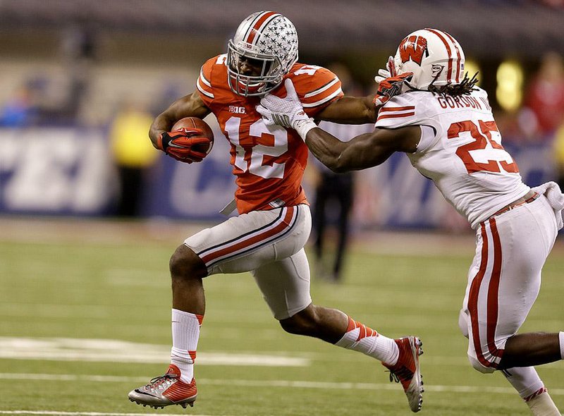 Ohio State cornerback Doran Grant, left, pushes past Wisconsin running back Melvin Gordon after intercepting a pass during the second half of the Big Ten Conference championship NCAA college football game Saturday, Dec. 6, 2014, in Indianapolis. (AP Photo/Michael Conroy)