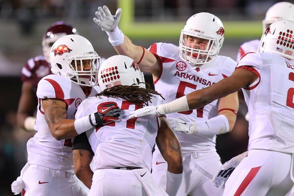 Arkansas celebrates after Alan Turner (27), center, intercepted a pass in the first quarter against No. 1 Mississippi State on Nov. 1, 2014, in Starkville, Miss.