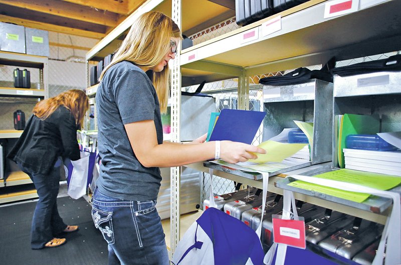  STAFF PHOTO DAVID GOTTSCHALK Laura Johnson, field technician with the Washington County Election Commission, prepares supervisor notebooks, information and ballot boxes Monday at the Washington County Election Commission in Fayetteville.