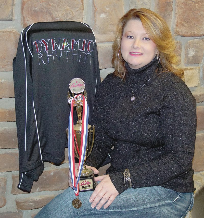 Photo by Randy Moll Jodi Moore, dance instructor and business owner, paused from work in her dance studio on Gravette&#8217;s Main Street last week for a photo holding a national dance award. Moore plans to open Dynamic Rhythm soon, with an open house set for this month and with classes beginning in January.