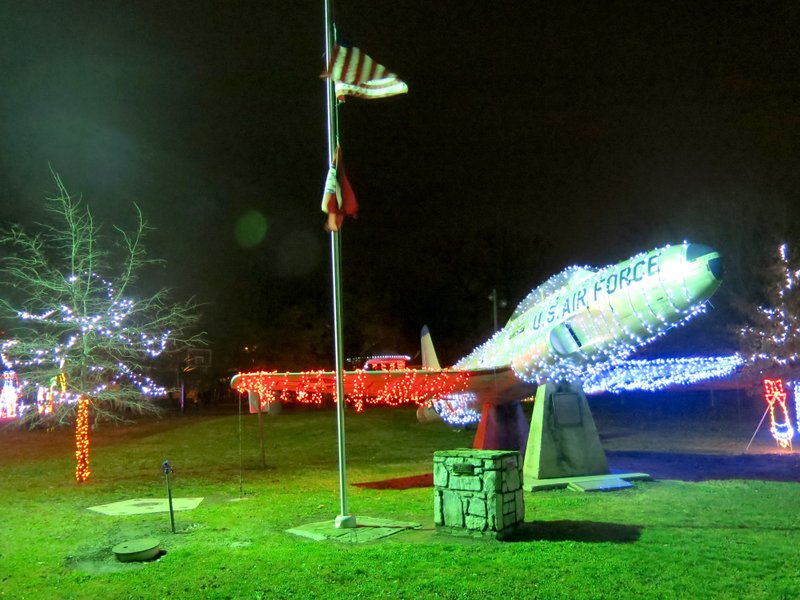 Photo by Susan Holland The Lockheed T-33 jet at the southwest corner of Kindley Park is adorned in red, white and blue lights for the holiday season. The U.S. and Arkansas flags beside the plane can also be seen bathed in the light from the seasonal displays. The plane, honoring Capt. Field Kindley, is on loan to the City of Gravette, courtesy of the National Museum of the United States Air Force.