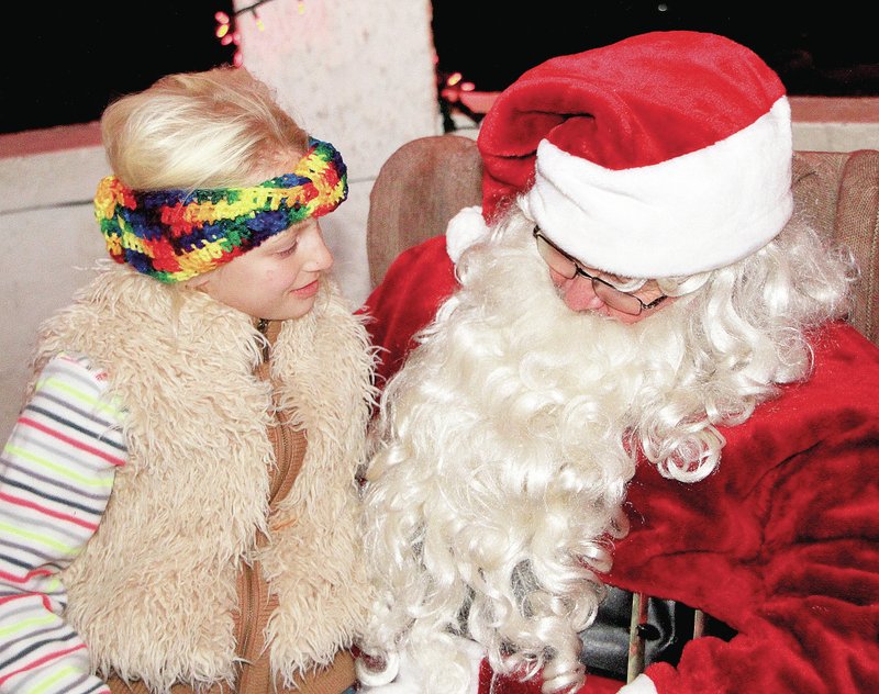 Photo by Steve Huckriede Stormey Jo Pembleton visits with Santa in the pavilion at Kindley Memorial Park in Gravette on Saturday night, following the Christmas Parade.