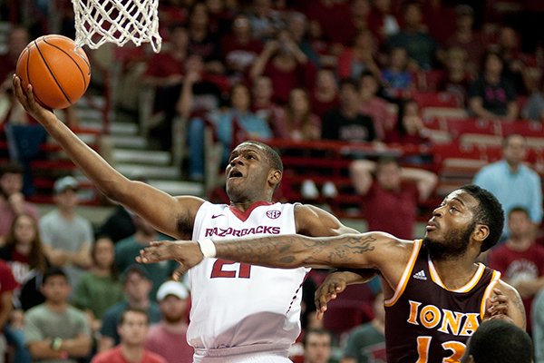 Arkansas' Manuale Watkins (21) reaches up for the basket over Iona's David Laury (13) in the second half of an NCAA college basketball game in Fayetteville, Ark., Sunday, Nov. 30, 2014. Arkansas won 94-77. (AP Photo/Sarah Bentham)