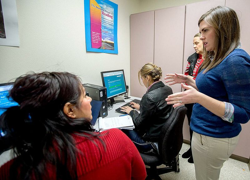 Casey Trzcinski (right) with Legal Aid of Arkansas helps Patricia Ruan of Rogers obtain health insurance during an event on Wednesday at the Northwest Arkansas Community College Adult Education Center inside the Center for Nonprofits in Rogers.