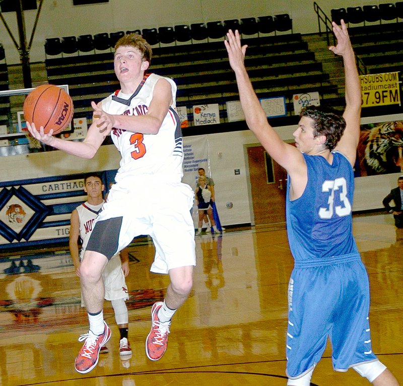 RICK PECK MCDONALD COUNTY PRESS Drew Harmon gets past Carthage&#8217;s Jesse Martini for a layup during McDonald County&#8217;s 50-43 loss in the opening round of last week&#8217;s Carthage Tournament.