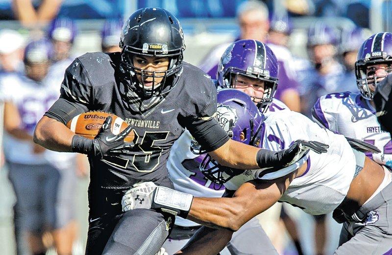  STAFF PHOTO JASON IVESTER Dylan Smith, Bentonville senior running back, pushes off a tackle attempt from a Fayetteville defender during the 7A championship game Dec. 6 at War Memorial Stadium in Little Rock.