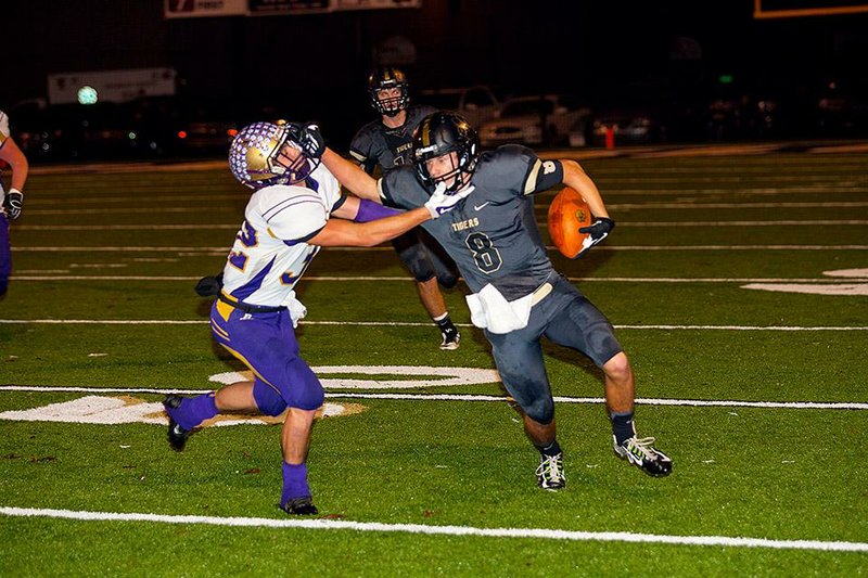 #8 Dylan Jones of Charleston stiff-arms #32 Josh Smith of Booneville after a short pass receiption.