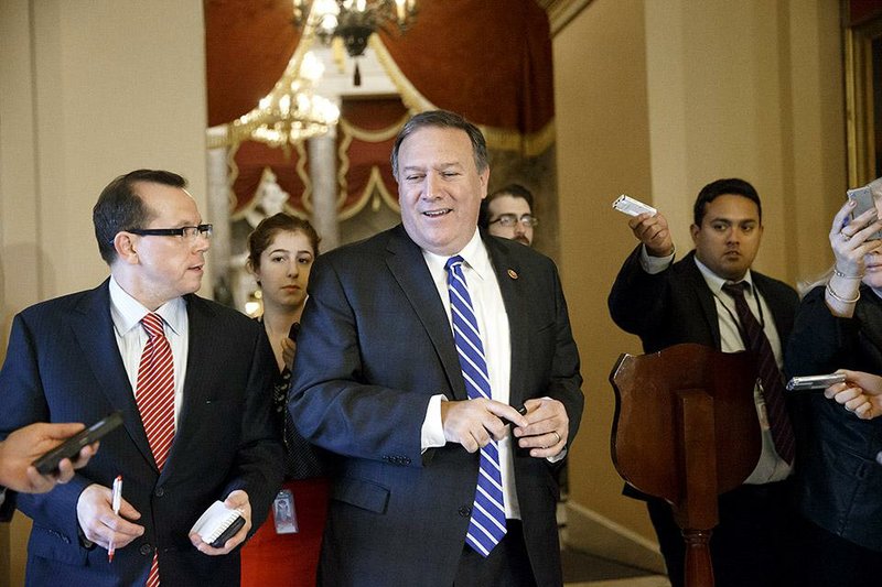 Rep. Mike Pompeo, R-Kan., is pursued by reporters at the Capitol as the House Republican leadership works to muster votes for final passage of the omnibus spending bill to fund the government, in Washington, Thursday, Dec. 11, 2014. Earlier in the day, conservatives sought to torpedo the measure because it would leave Obama's immigration policy unchallenged, but Speaker John Boehner patrolled the noisy, crowded House floor looking for enough GOP converts to keep it afloat. (AP Photo/J. Scott Applewhite)